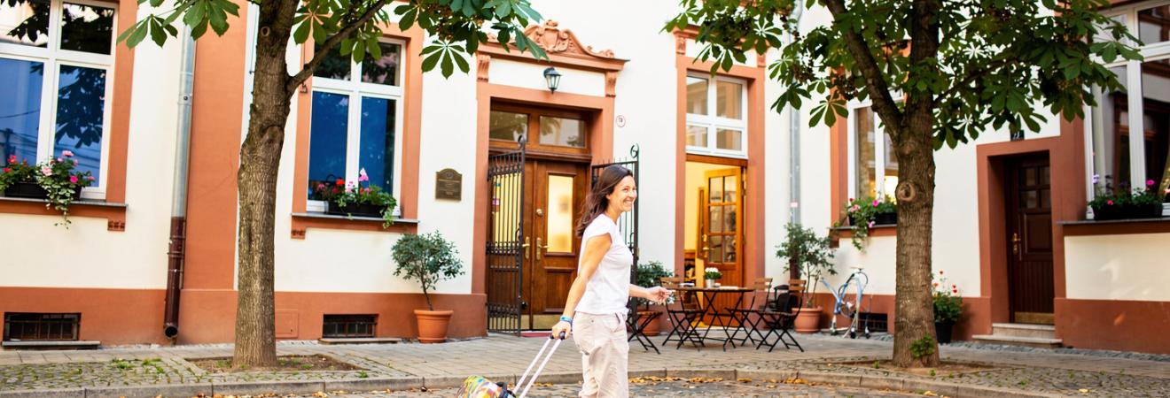 Frau mit Koffer in einem Krakauer Innenhof.
