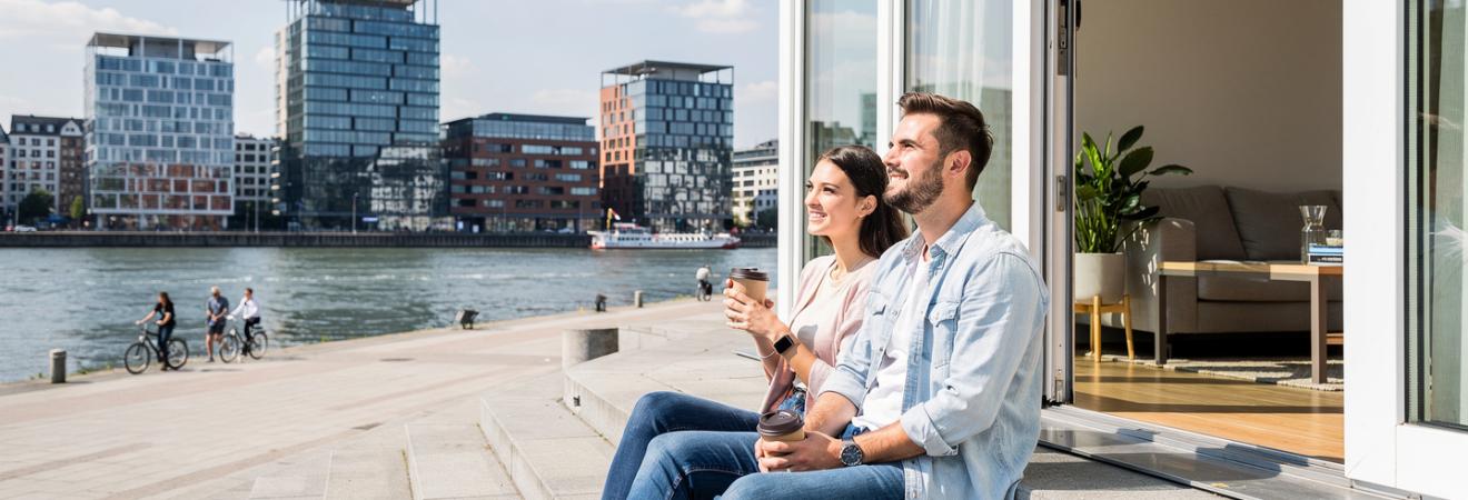 Zwei Studierende sitzen an der Rheinuferpromenade in Düsseldorf.