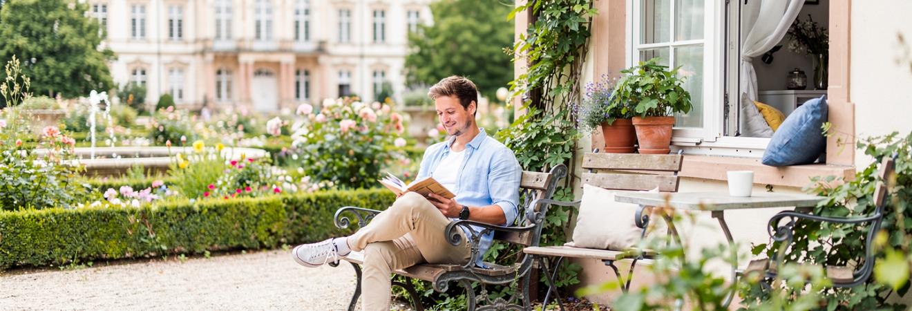 Student liest auf einer Bank im Karlsruher Schlossgarten.